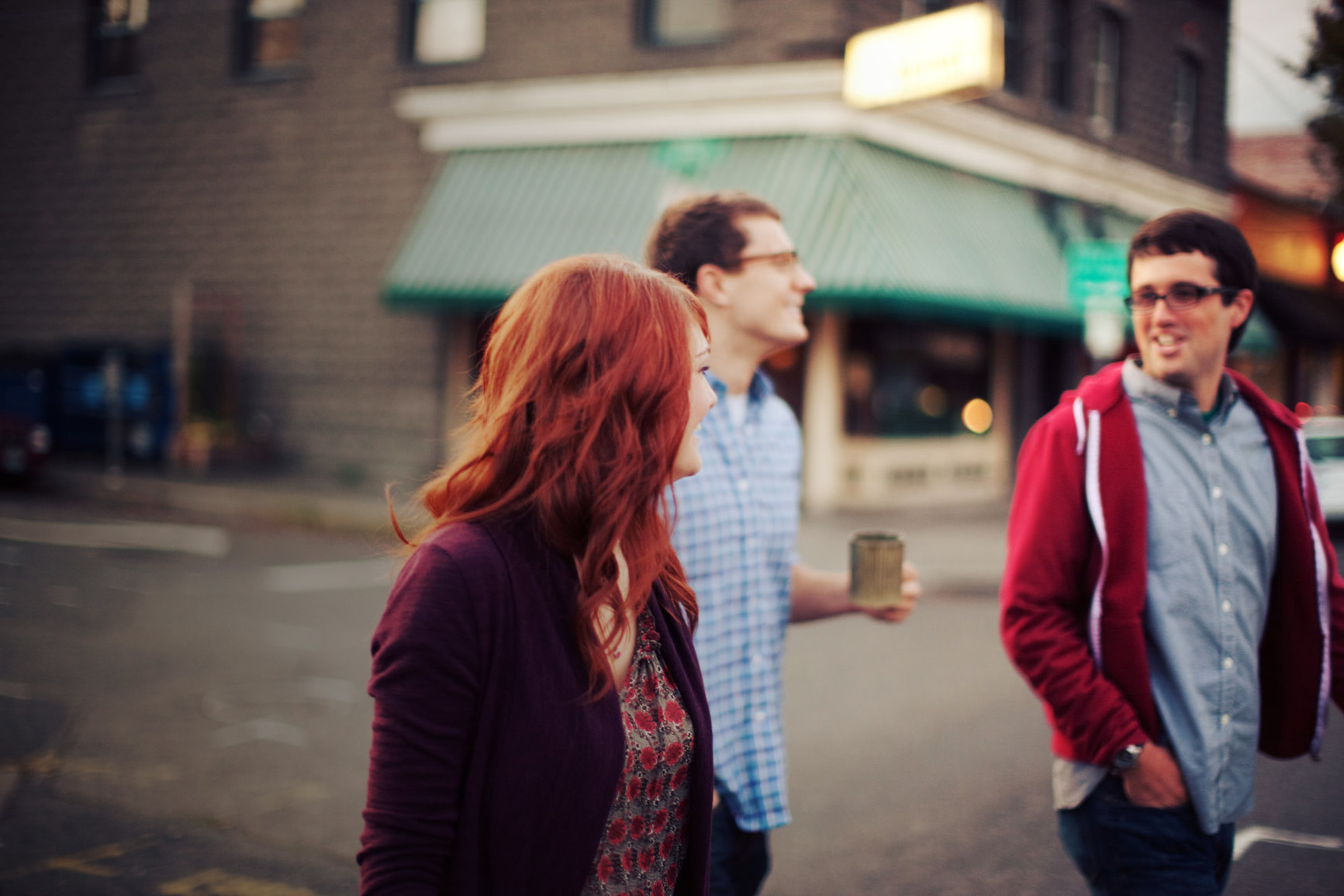 Young people drinking coffee and crossing the street